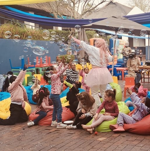 Bella entertaining a seated audience of children with bubbles